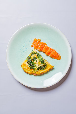 Spinach omelette with vibrant smoked salmon, beautifully plated for breakfast.の写真素材