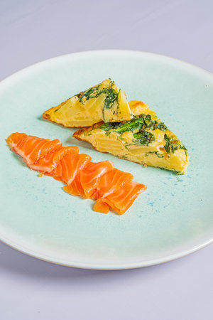 A vibrant omelette with herbs and fresh salmon slices.の写真素材