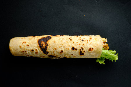 Savor a warm, flavorful wrap packed with crisp lettuce and tasty fillings, ideal for lunch.の写真素材
