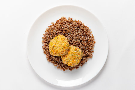 Two golden patties on a bed of buckwheat make a nourishing meal option.の写真素材