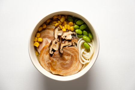 Rich flavors mingle in a bowl featuring succulent pork, vibrant corn, and fresh shiitake mushrooms.の写真素材