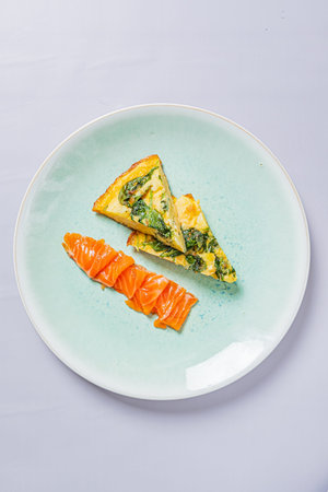 Brunch plate featuring a spinach frittata slice and fresh salmon.