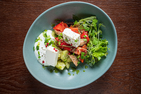 A colorful arrangement of fresh vegetables, creamy feta, and herbs enhances a delightful meal.の写真素材
