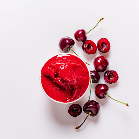 Delicious cherry sorbet offers a refreshing treat, accompanied by vibrant, juicy cherries nearby.