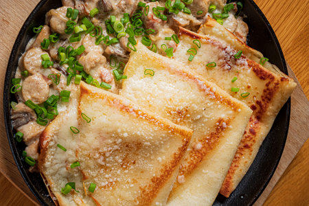 Savory crepes stuffed with rich mushroom sauce and topped with bright green onions.