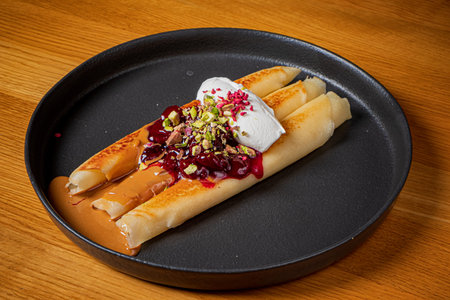 Savory crepes artfully plated with creamy toppings and crunchy nuts.
