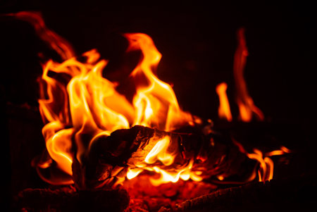 Flickering flames rise and sway against a black backdrop, casting enchanting shadows and warmth.の写真素材