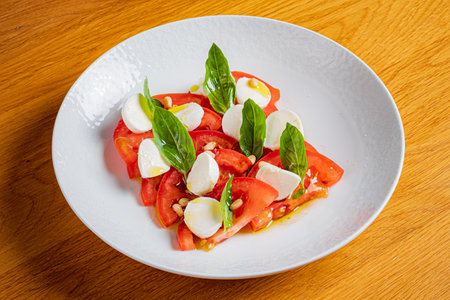 A tasty mix of ripe tomatoes, creamy mozzarella, and basil makes a colorful dish.の写真素材