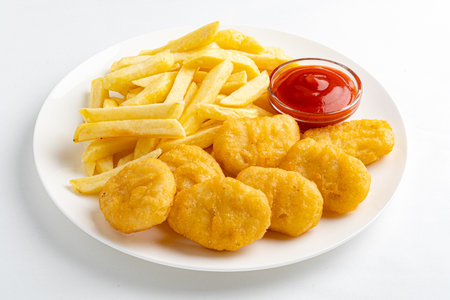 A tempting plate of golden chicken nuggets accompanies crispy fries and a side of ketchup.の写真素材