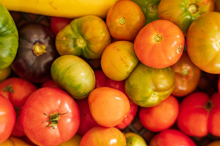 A basket filled with colorful heirloom tomatoes showcases nature's bounty.の写真素材