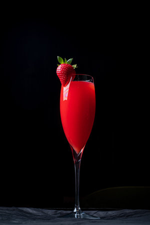 Sipping on a refreshing berry drink garnished with a fresh strawberry while enjoying a quiet moment.