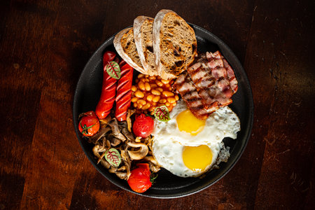 Feasting on a hearty breakfast with sunny-side-up eggs, crispy bacon, and grilled mushrooms.の写真素材