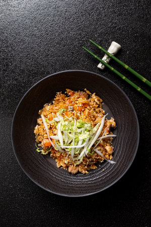 Enjoy the vibrant textures and flavors of special fried rice topped with fresh veggies.の写真素材
