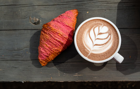 Enjoying a latte with art and a vibrant pastryâperfect for a cozy morning!の写真素材