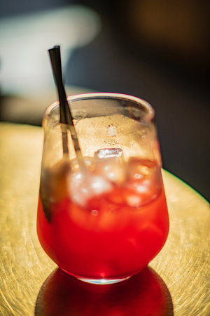 A refreshing cocktail glows gently in a glass, creating a relaxed ambiance.の写真素材