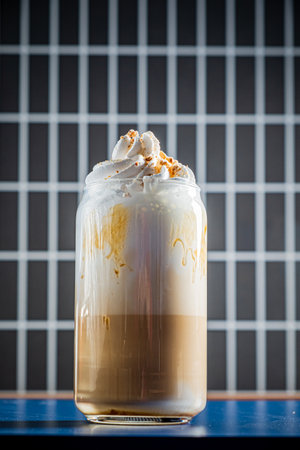 A glass brimming with coffee layers and fluffy whipped cream captures the cafÃ© ambiance beautifully.の写真素材