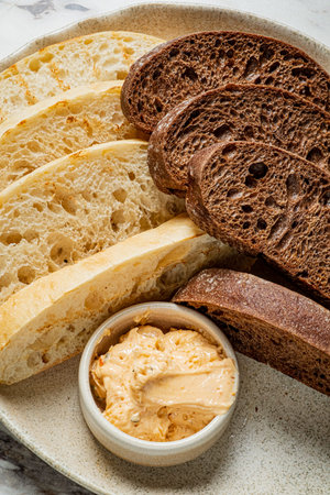 Freshly baked artisan bread varieties paired with a smooth, savory butter for a delightful snack.
