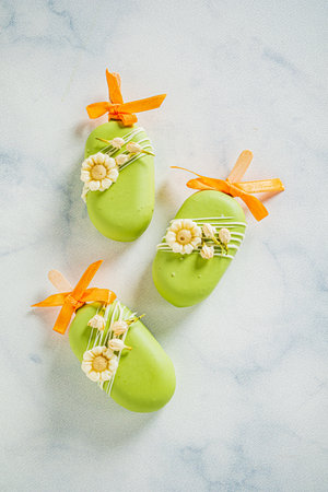 Colorful green treats adorned with flowers and ribbons await at a joyful celebration.の写真素材