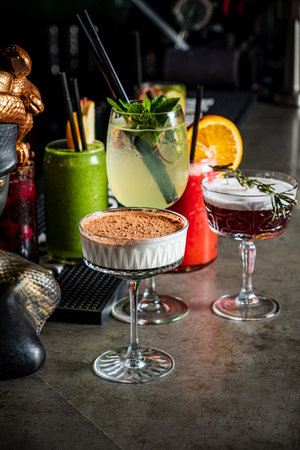 Colorful cocktails and a stunning dessert create an inviting atmosphere, perfect for socializing.の写真素材