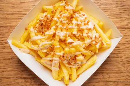 Fries are drizzled with rich sauce and topped with crunchy bits, tempting your taste buds.