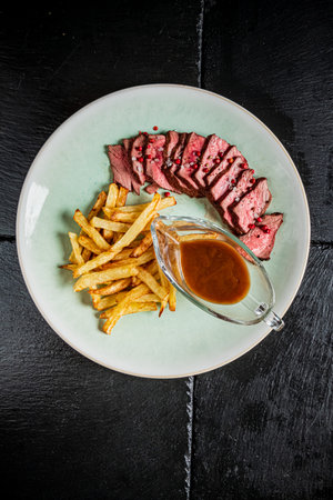 Tender pieces of steak with golden fries and rich sauce create a delicious meal.