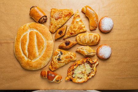 A tempting selection of various pastries and bread arranged artistically on a wooden table.