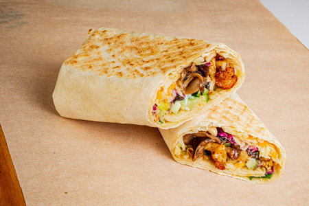 Tasty wrap loaded with savory grilled chicken, crunchy veggies, and creamy sauce, perfectly rolled.の写真素材