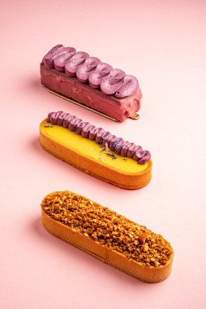 Three unique desserts with varied flavors on a soft pink backdrop.の写真素材