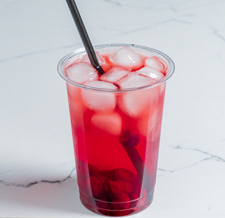 Colorful berry beverage with ice in a transparent cup, perfect for a warm day.の写真素材