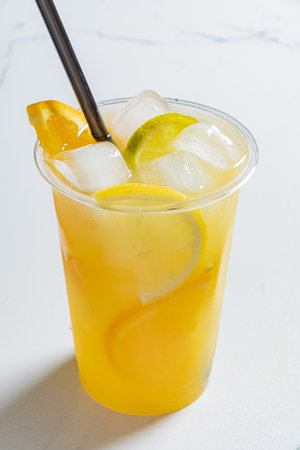 A vibrant drink filled with ice, lemon, and orange slices, ideal for hot days and relaxation.の写真素材