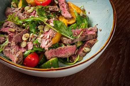 A tasty mix of grilled steak, fresh greens, and cherry tomatoes makes a vibrant salad.の写真素材