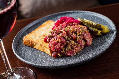 Savoring beef tartare with toast, pickles, and onionsâperfect for casual dining!の写真素材