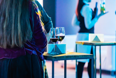 Guests enjoy a wine tasting event with stylish decor and soft lighting, creating a lively ambiance.の写真素材