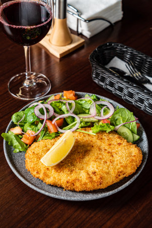 Savor a crispy schnitzel with fresh salad and zesty lemon, perfect for lunch!の写真素材
