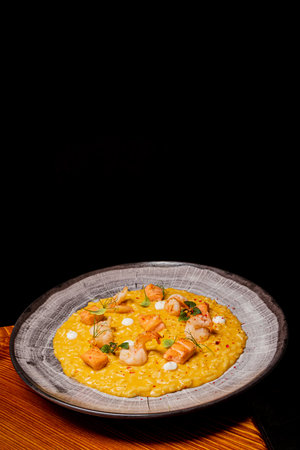 A colorful plate of risotto with shrimp, saffron, and herbs invites indulgence.の写真素材