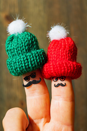 Two playful finger characters sport vibrant hats and mustaches, spreading cheer and fun.の写真素材