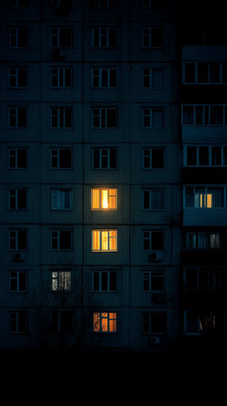 Soft light from Khrushchyovka windows illuminates the night, revealing glimpses of life.の素材