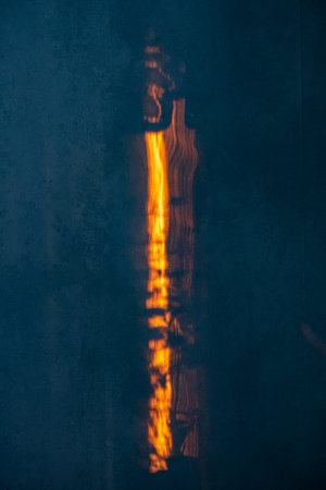 Soft light spills through a crack, illuminating dark textures and creating abstract patterns.の写真素材