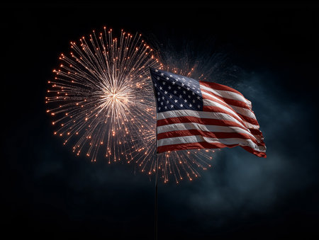 Beautiful fireworks explode in the night sky, highlighting the American flag on Independence Day.の素材