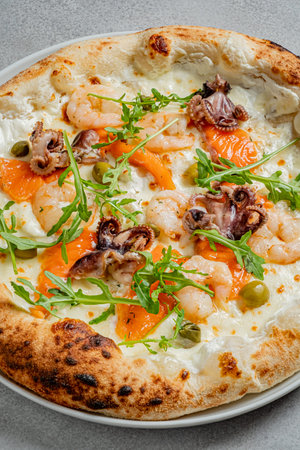 An exquisite seafood pizza features shrimp, octopus, and fresh greens on a crispy crust.の写真素材