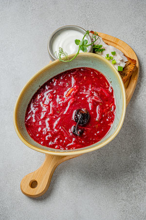 Rich red borscht with beets, served with fresh bread and a dollop of sour cream on the side.の写真素材