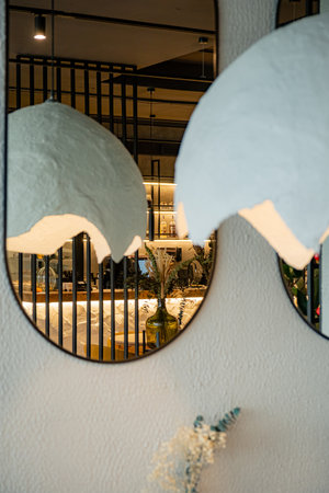 Soft light from pendant lamps reflects in chic mirrors, creating a cozy atmosphere.の写真素材