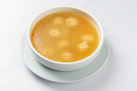 Delicious broth with floating dumplings creates a warm and inviting atmosphere in a kitchen.の写真素材