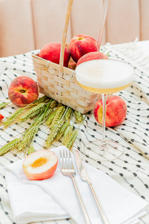 Fresh peaches surround a chic drink on a stylish table, creating a sunny summer vibe.の写真素材