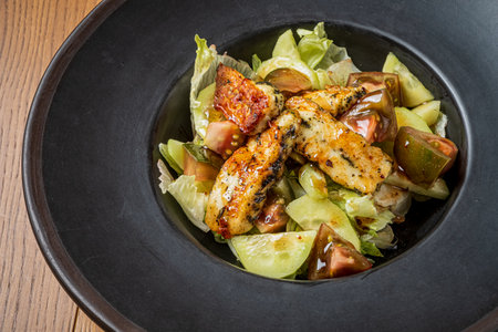 Grilled chicken atop fresh greens and veggies, bursting with color and flavor.の写真素材