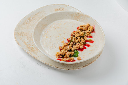 A creamy cereal bowl topped with vibrant fruits and crunchy granola makes a delightful breakfast.の写真素材