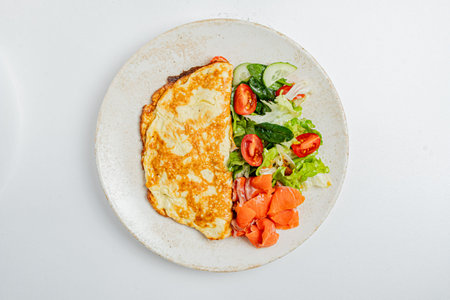 Savor a fluffy omelette, crisp salad, and succulent salmon for a vibrant breakfast.の写真素材