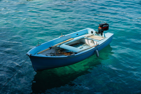 A charming blue boat rests quietly in tranquil waters, surrounded by shimmering waves and sunlight.