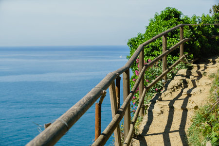 A wooden railing guides visitors along a winding coastal path, offering stunning ocean views.
