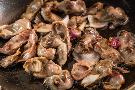 Juicy pieces of meat are sizzling in a hot pan, creating an irresistible aroma in the kitchen.の写真素材